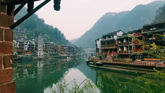 Traditional riverside houses reflected in the Tuo River at Fenghuang Ancient Town