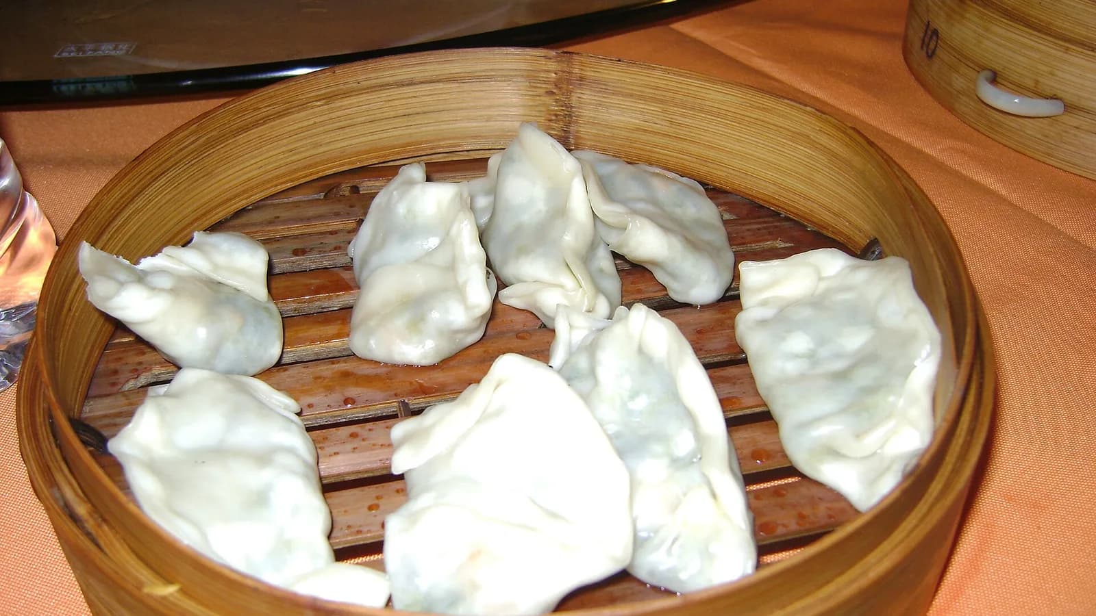 Travelers folding dumplings with a Chinese cooking teacher