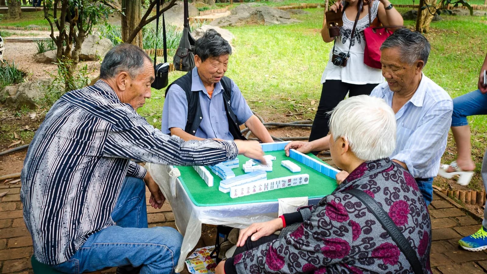 Four people learning mahjong around a table in a Chengdu tea house