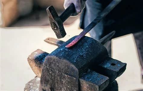 A craftsperson forging a sword by hand in Dengfeng